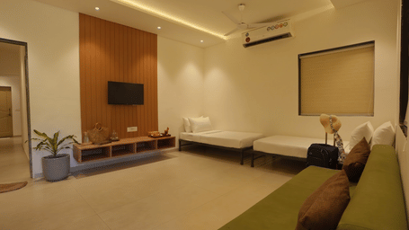 a living room with sofas, a television, and lights. 