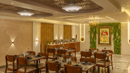 Restaurant dining area with wooden tables and chairs at Perfectstayz Premium Vrindavan.