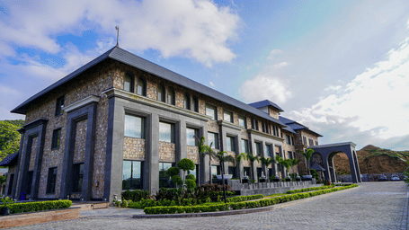 A low-angle shot of a multi-storey stone and glass building, which is the main part of the resort.