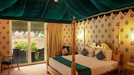 Image of Royal Luxury Tent a bed and an attached balcony on the side at Rajasthali Resort & Spa Jaipur.