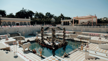Outdoor poolside area decorated for a wedding celebration with flowers and drapes