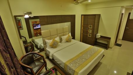 An expansive view of a well-appointed hotel room featuring a bed, seating, and contemporary decor - Retreat Heritage, Lonavala