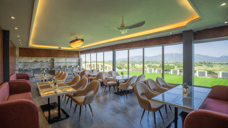 The bright, modern dining area at Sukoon by the Ganges features floor-to-ceiling windows with lovely outdoor views.