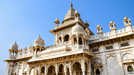 A white marble mausoleum, the Jaswant Thada, stands under a blue sky.