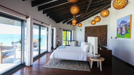 Ocean-facing bedroom with exposed beams and sliding glass doors at Tamarind Hills Resort and Villas - Antigua