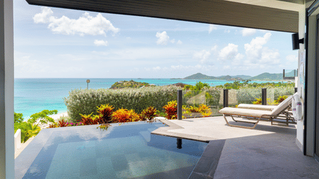 Seastar Suite at Tamarind Hills Resort and Villas, Antigua, featuring an outdoor terrace with pool, lounge chairs at poolside, and a scenic view