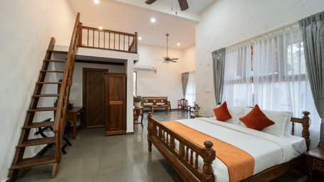 Tapovana room with a double bed and a loft area at TGI Hotels & Resorts