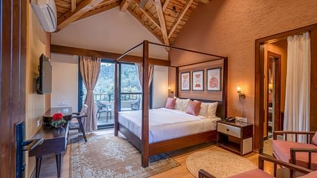 Bedroom with a four-poster bed and a view through large windows with curtains pulled to the sides at The Chamomile Estate.