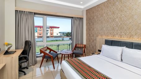 A hotel room with a bed, a work desk, and a seating area near a window with curtains | The Citi Residenci Hotel Banskopa