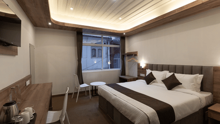 image of the Standard room with a king size bed and a window in the corner at The Soma Hotel by Avianna Group, Darjeeling