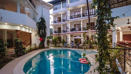 View of a central swimming pool surrounded by balconies and lush greenery at The Verda de Miranda Resort.