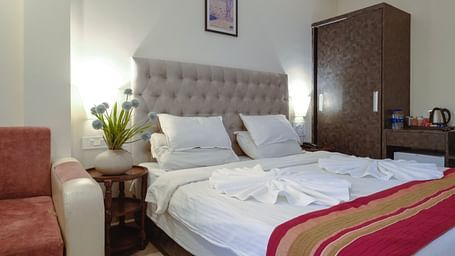A cosy bedroom featuring a padded headboard, bed, and warm lighting – The Verda de Miranda Resort.