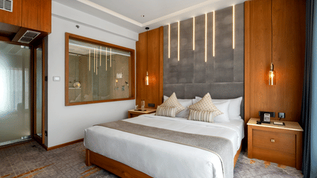 A hotel bedroom featuring a king size bed and wood panelled walls at Tiara by MPS.