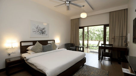 A wide-angle shot of the Studio highlighting the desk area, ceiling fan, and elegant neutral-toned curtains | Trance Sunderban Resort