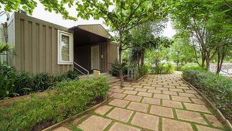 A facade image of a pathway featuring a room on the left side of it with greenery around - Trance Veechika Resort, Vikarabad
