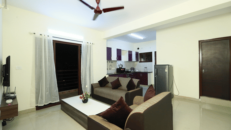 Living area with sofa seating and a coffee table at Tranquil ABS Orchid Serviced Apartments.