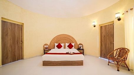 Front view of a room with a bed and a rattan chair on the side at Valley by Grassfield.