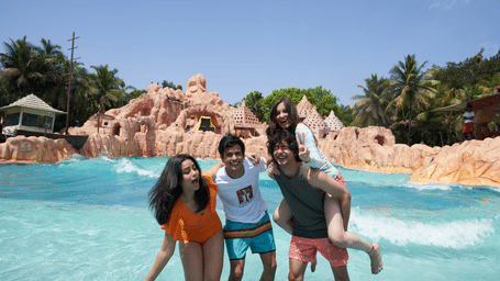 An overview of a group of people enjoying themselves in Wetlantic wave pool at Water Kingdom.