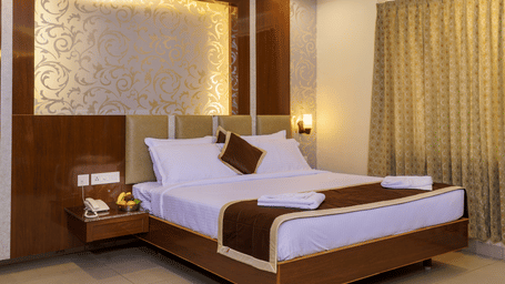 A room at Wyt Hotels, Rameswaram featuring a double size bed, bedside table, and lights installed behind the walls.