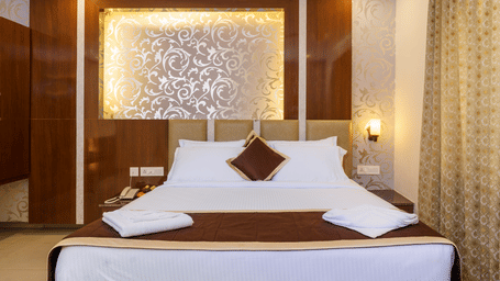 Deluxe room with bed and pillows at Wyt Hotels, Rameswaram