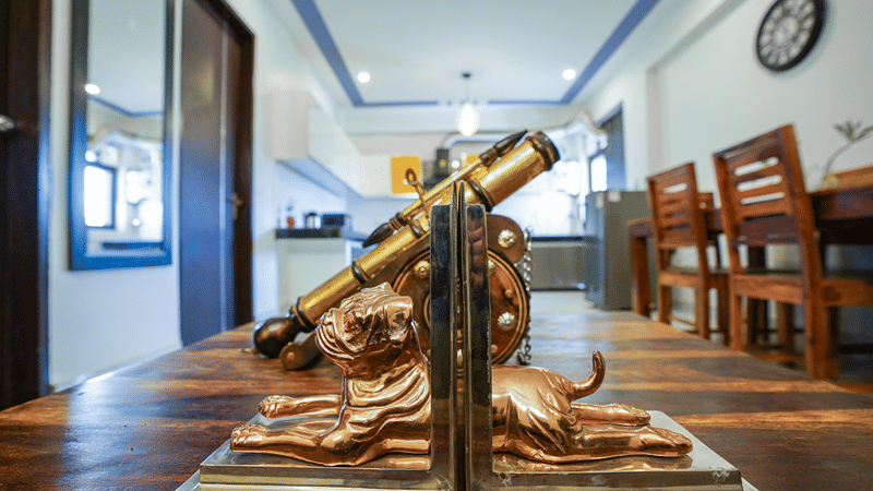 Corridor and dining area of Lime Tree Hotels & Service Apartment Private Limited featuring a decorative telescope and wooden flooring.