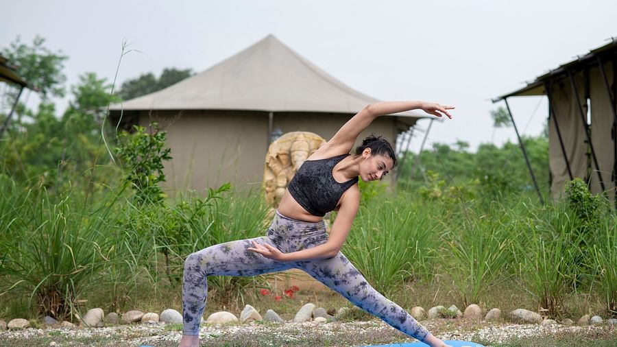 A woman doing yoga in front of tent near Haridwar - Aalia Jungle Resort & Spa