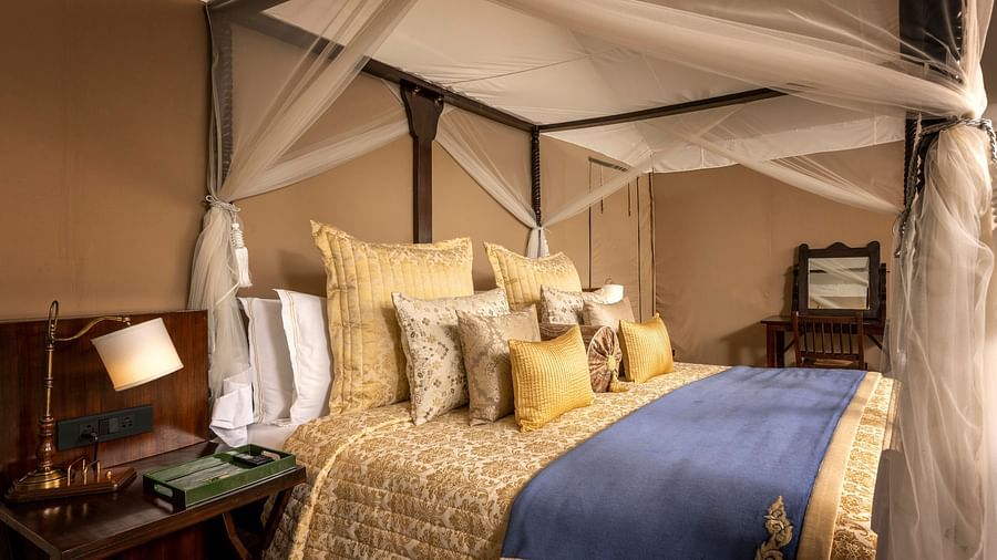 luxury king tents with a bed and a nightstand with a lamp - Aalia Jungle Resort & Spa