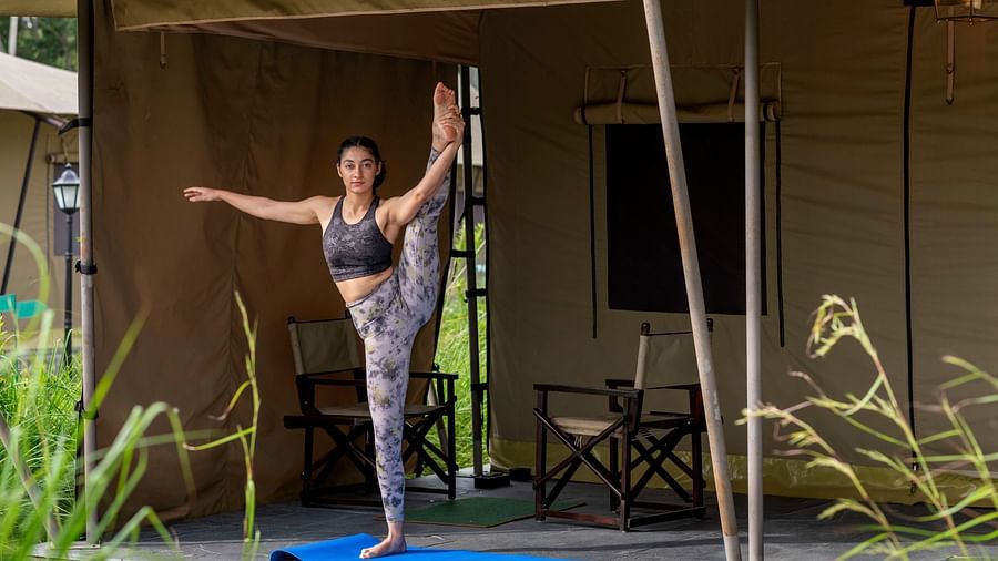 A woman striking a yoga pose in front of our tent near Haridwar - Aalia Jungle Resort & Spa