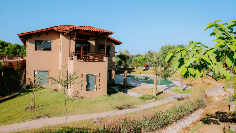 A resort building surrounded by a well-maintained garden and pathways at Aamaghati Wildlife Resort.