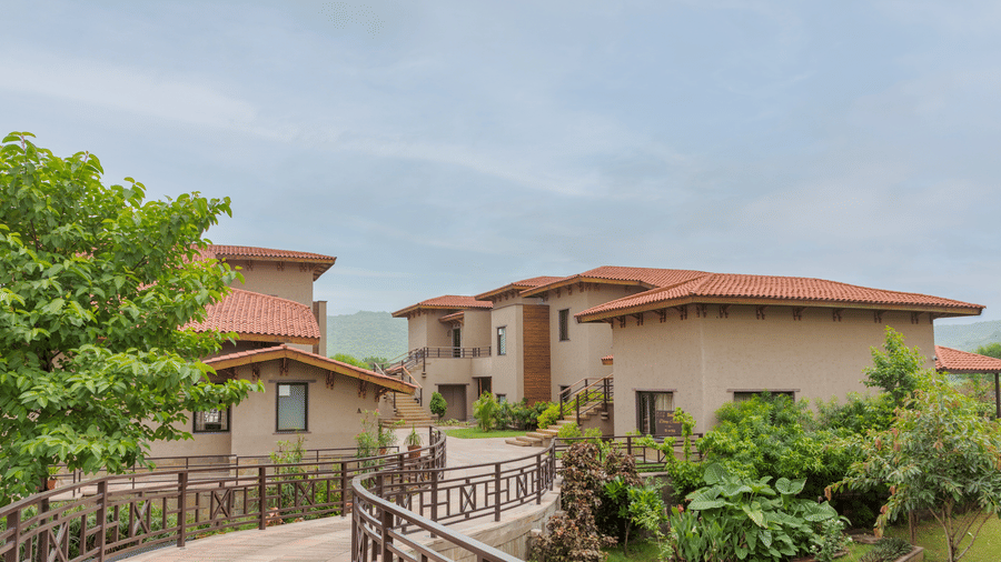The beautifully designed exterior of resort buildings surrounded by greenery at Aamaghati Wildlife Resort.