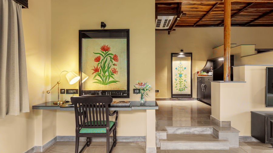 A well-appointed desk area with colourful artwork and steps at Aamaghati Wildlife Resort.