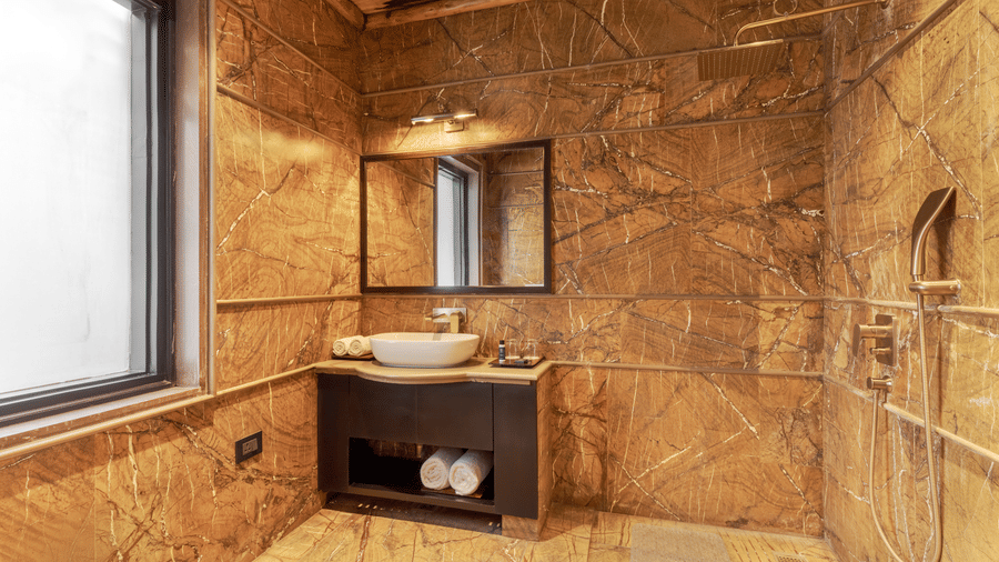 A well-appointed bedroom with a four-poster bed and elegant decor at Aamaghati Wildlife Resort.