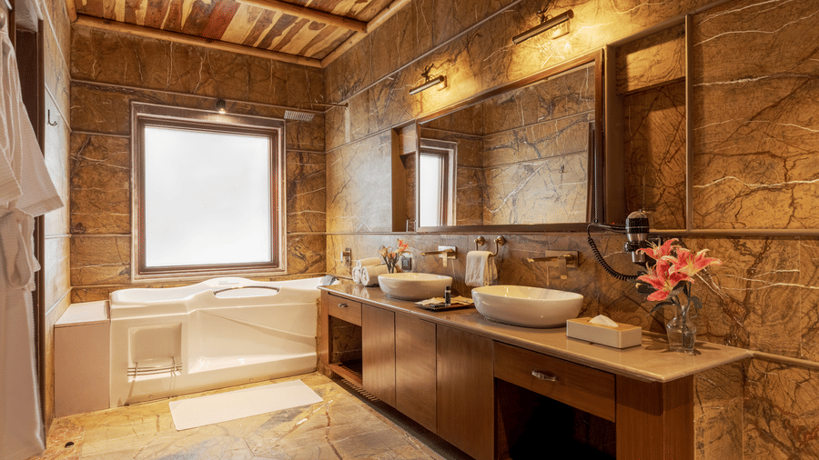 A wide shot of the comfortable living and dining space in a resort suite at Aamaghati Wildlife Resort.