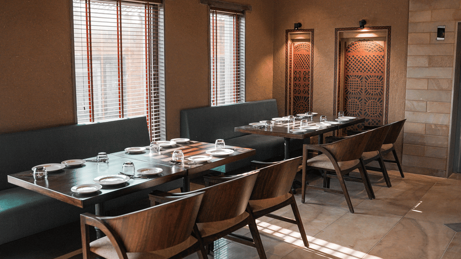 A wide view of the restaurant interior with multiple dining tables at Aamaghati Wildlife Resort.