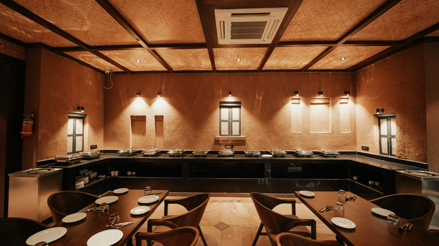 A well-lit buffet counter area in the restaurant with decorative lighting at Aamaghati Wildlife Resort.