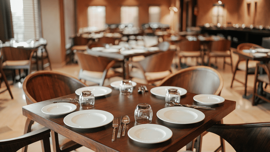 An empty restaurant with many set tables awaiting diners at Aamaghati Wildlife Resort.