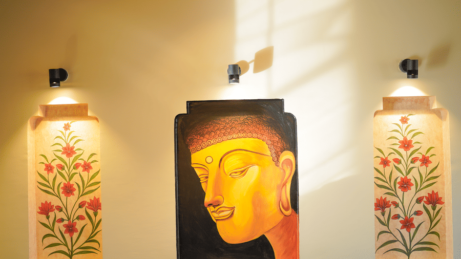 Vibrant wall art depicting Buddha and floral motifs in a spa area at Aamaghati Wildlife Resort.