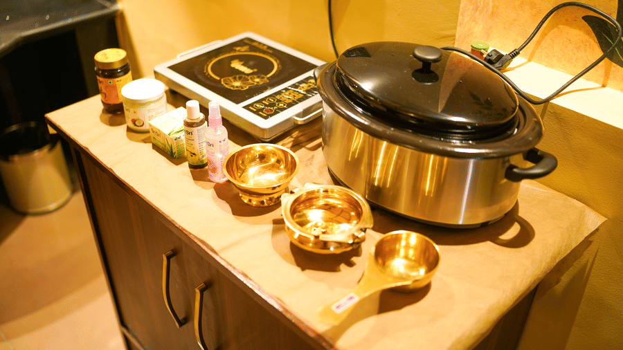 Traditional Ayurvedic treatment vessels and equipment on a counter at Aamaghati Wildlife Resort.
