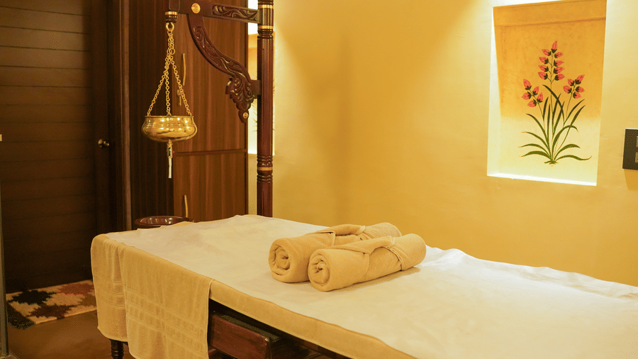 A neatly prepared massage bed with clean towels in a serene spa room at Aamaghati Wildlife Resort.