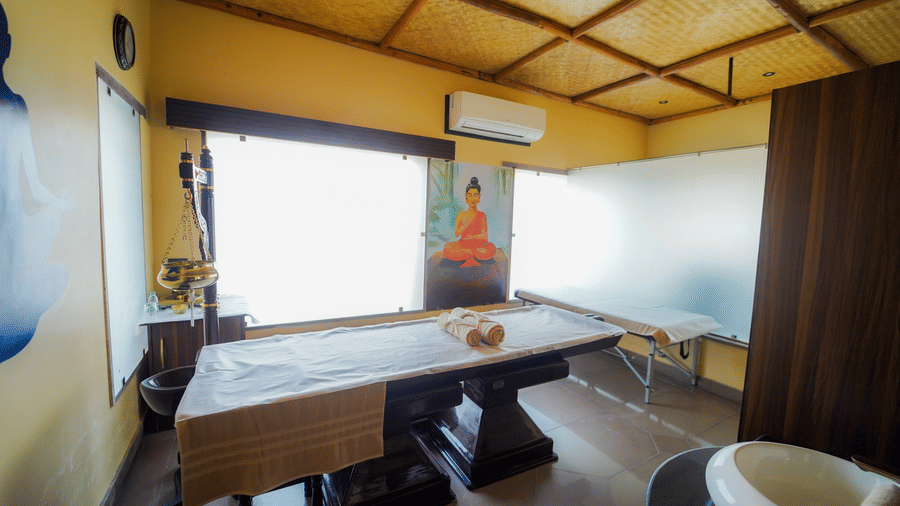 A spa room with a large window and natural light, featuring massage beds at Aamaghati Wildlife Resort.
