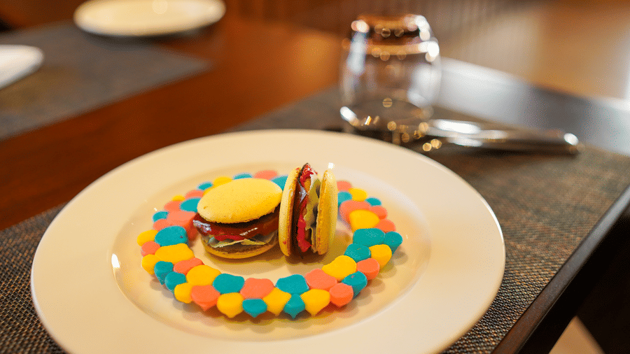 A colourful dessert presented on a white plate with cutlery at Aamaghati Wildlife Resort.