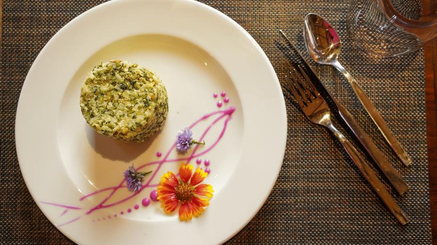A beautifully plated dish with a floral design on the side of the plate at Aamaghati Wildlife Resort.