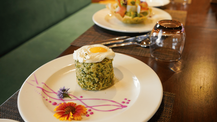 A close-up of a beautifully plated meal with a decorative element on the side at Aamaghati Wildlife Resort.