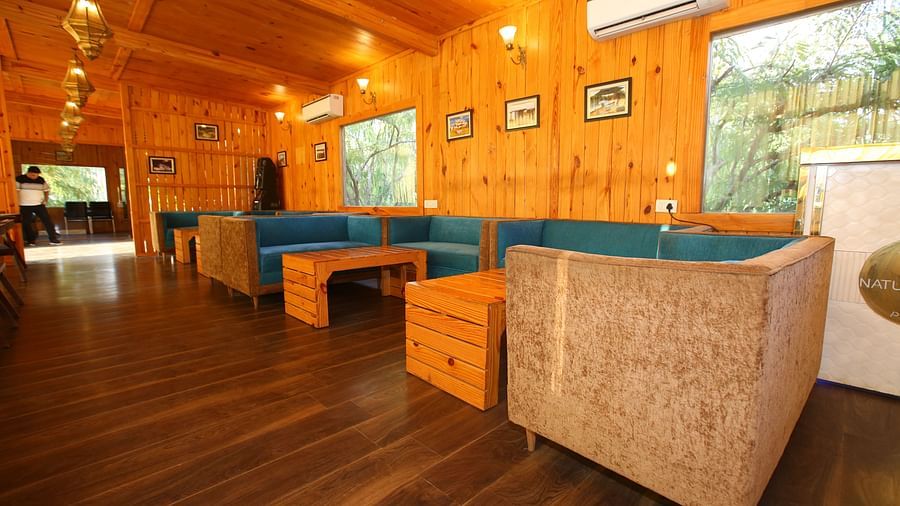 Dining area featuring a large, cozy sofa with a table in front at Aanandam Resort & Spa