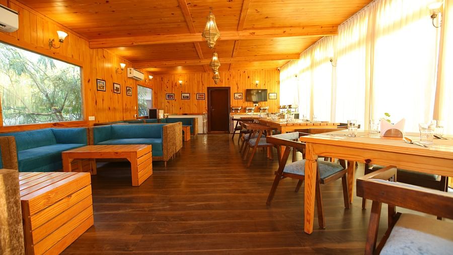 Dining area featuring a large, cozy sofa with a table in front at Aanandam Resort & Spa