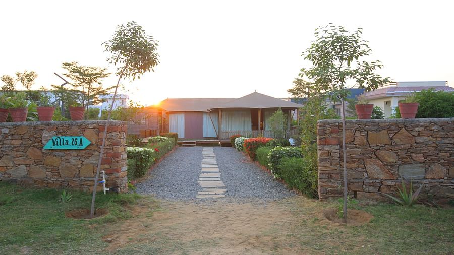 Front view of the Luxury Wooden Tent, with vibrant plants lining the pathway at Aanandam Resort & Spa