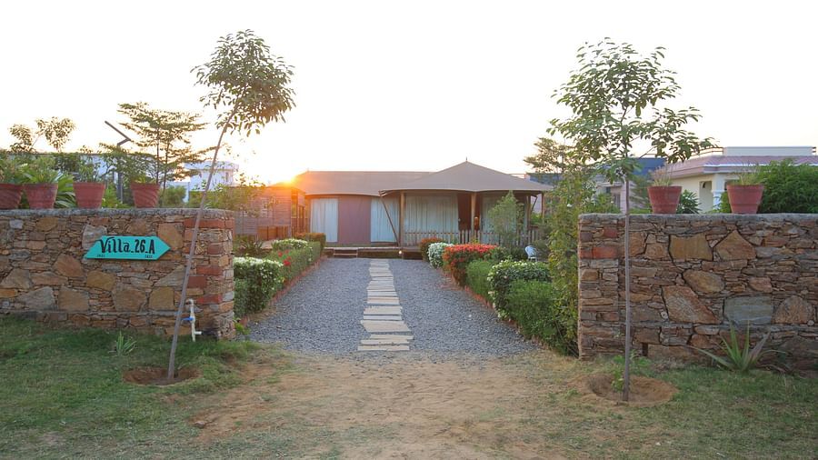 Front view of the Luxury Wooden Tent, with vibrant plants lining the pathway at Aanandam Resort & Spa