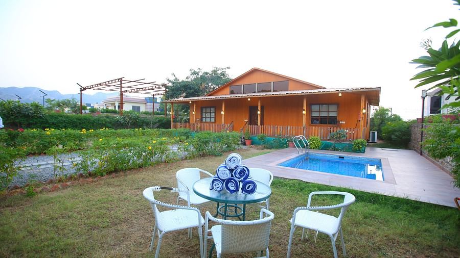 Outdoor swimming pool in front of the villa, with an open top to the clear sky and mountains in the background