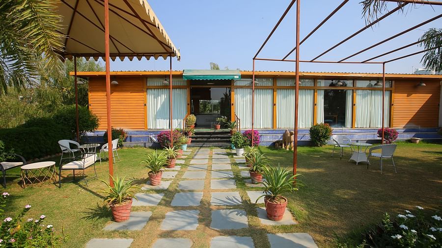 Elegant pathway leading into the hotel, featuring a roofed shed and small potted plants lining the side at Aanandam Resort & Spa