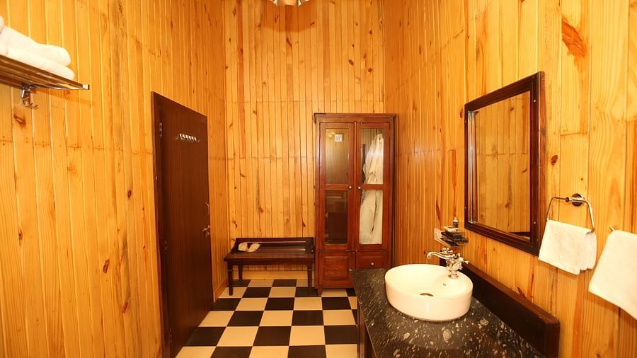 Washroom featuring a sleek sink, wooden walls, and a mirror mounted on the wall at Aanandam Resort & Spa